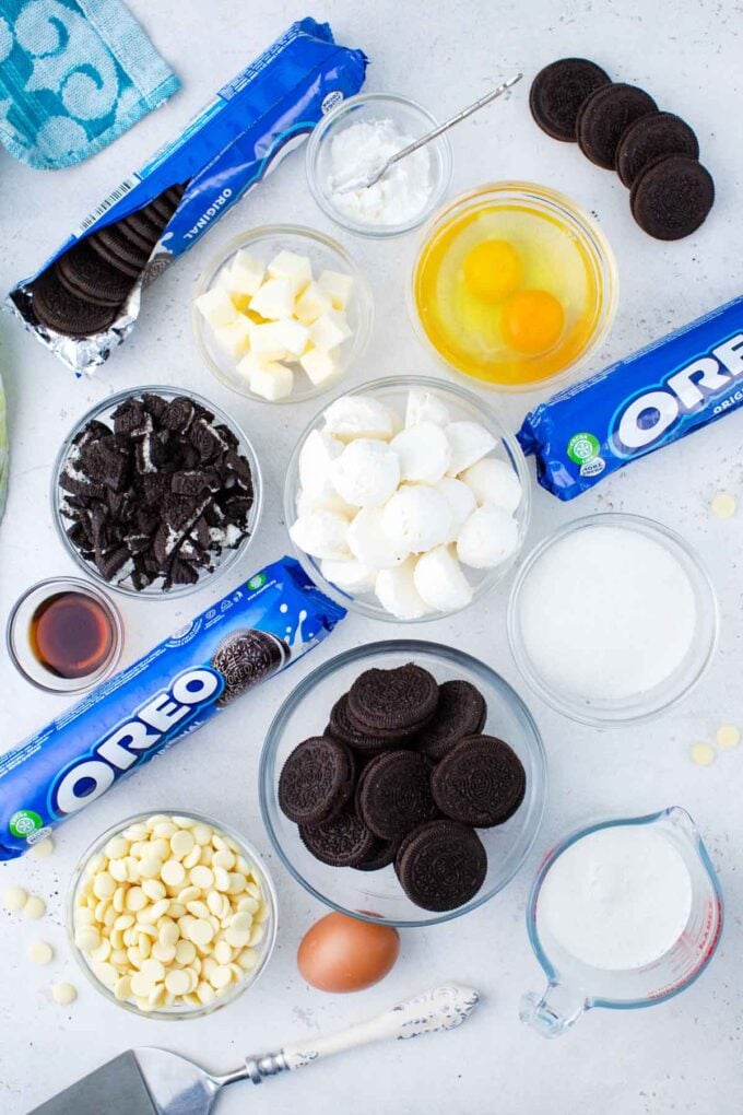 Instant Pot Oreo cheesecake ingredients in bowls on a white surface.