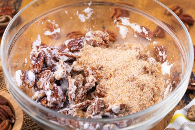 Tossing pecans with sugar and egg whites.