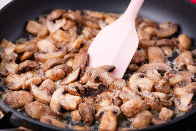 Sautéing mushrooms in a pan.