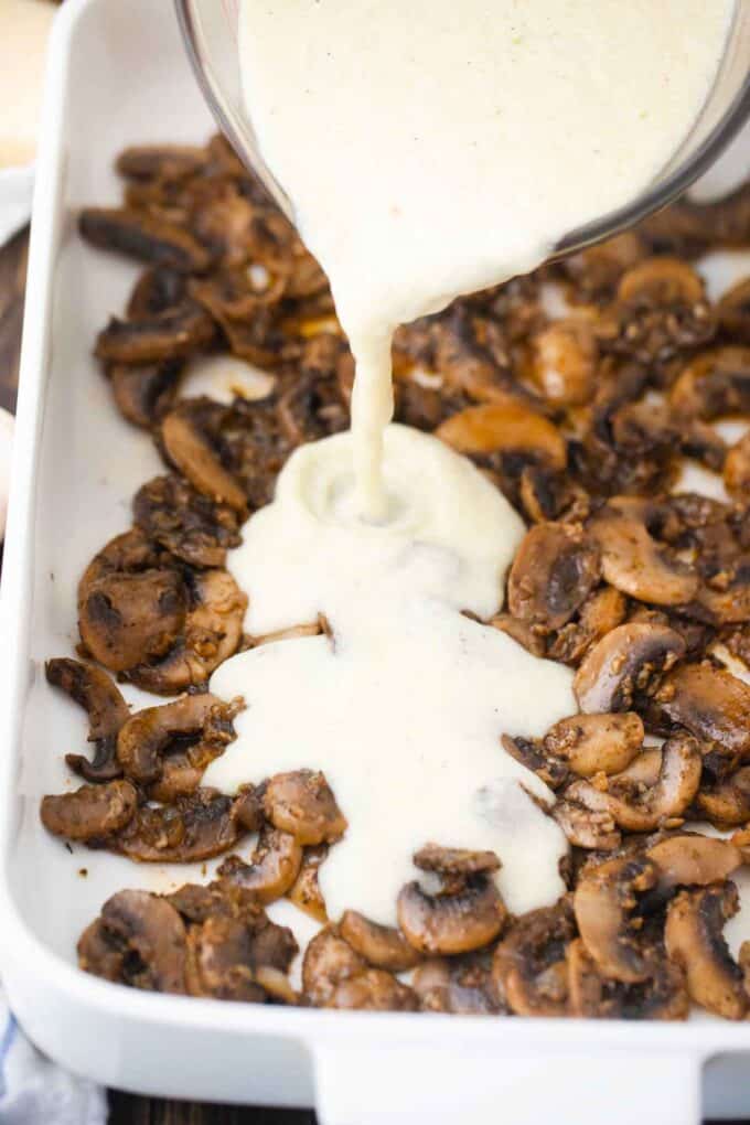 pouring sauce over sauteed mushrooms