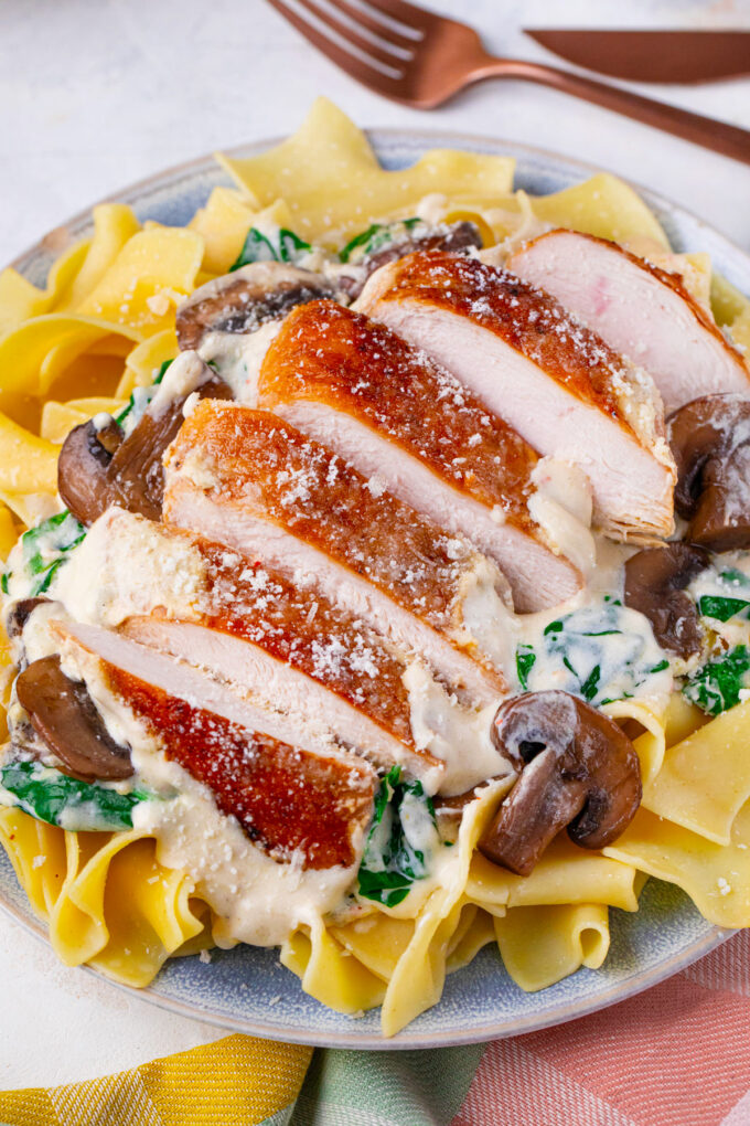 Sliced creamy parmesan mushroom chicken over egg noodles.
