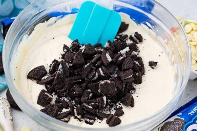 Stirring chopped Oreos into cheesecake batter.