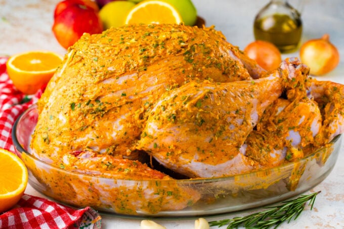 Roasting a whole turkey coated in a butter herb mixture.