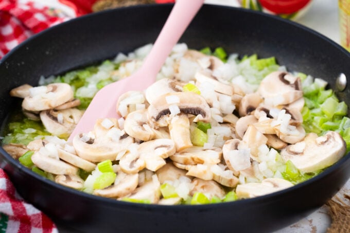 Sautéing onion, mushrooms, and celery in a skillet.