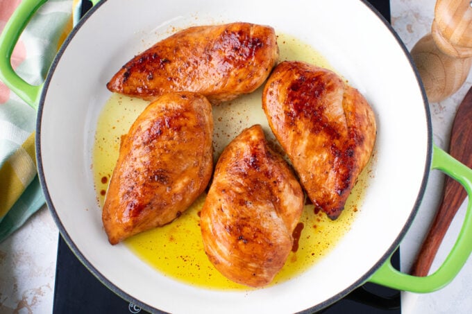 Perfectly seared chicken breasts in a pan.