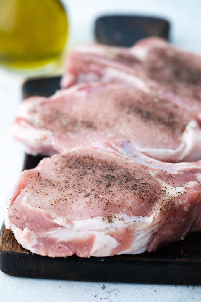 Seasoning bone-in pork chops.