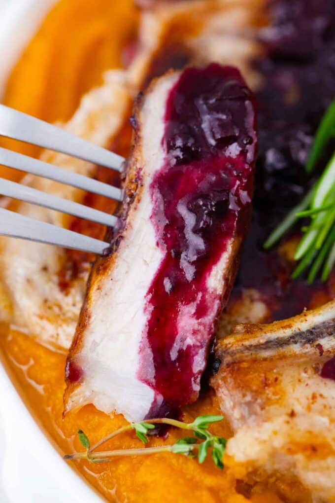 sliced tender pork chop topped with savory blueberry sauce