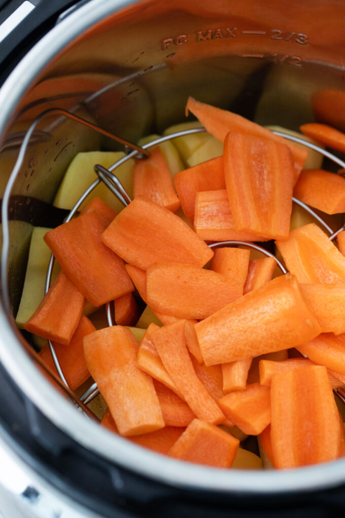 Adding carrots and potatoes to the Instant Pot.