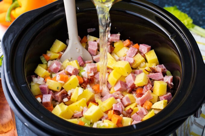 Combining the ingredients for slow cooker ham and potato soup.