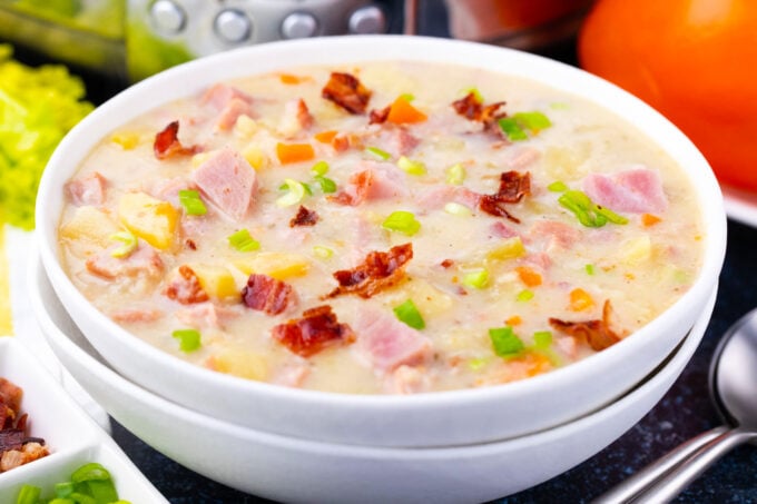 A bowl of creamy slow cooker ham and potato soup with bacon.