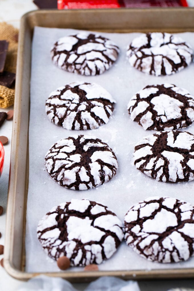 Chocolate crinkle cookies on a baking sheet.