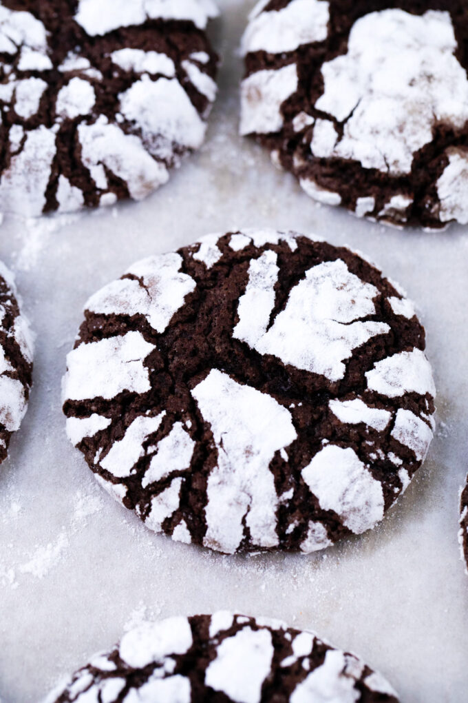 Chocolate crinkle cookies on a cookie sheet.