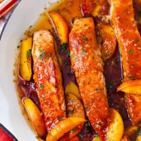 one pan peach salmon in a skillet with sliced peaches