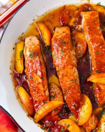 one pan peach salmon in a skillet with sliced peaches