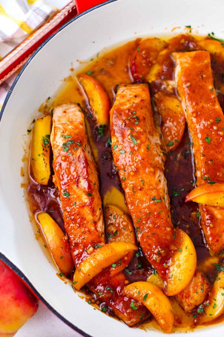 one pan peach salmon in a skillet with sliced peaches