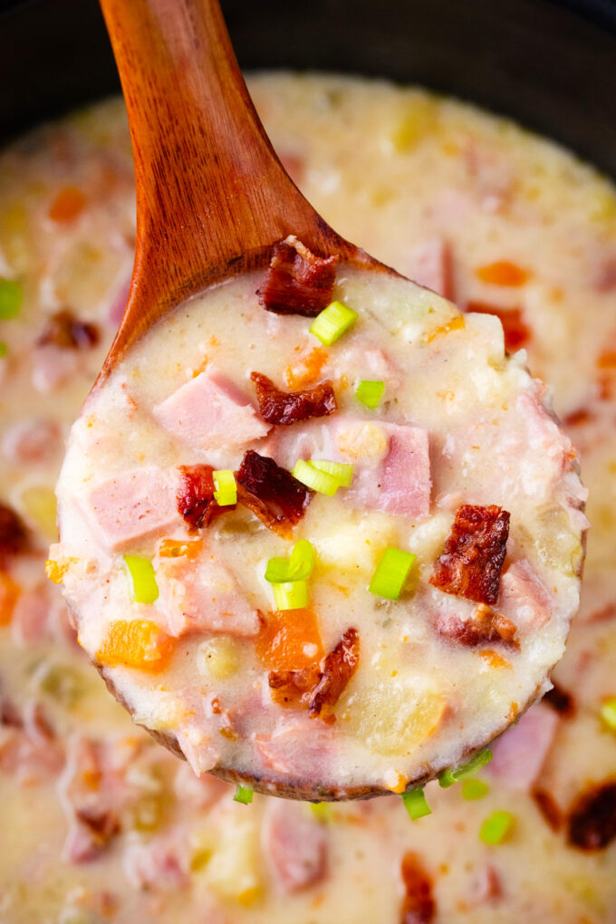 A ladle of creamy slow cooker ham and potato soup.