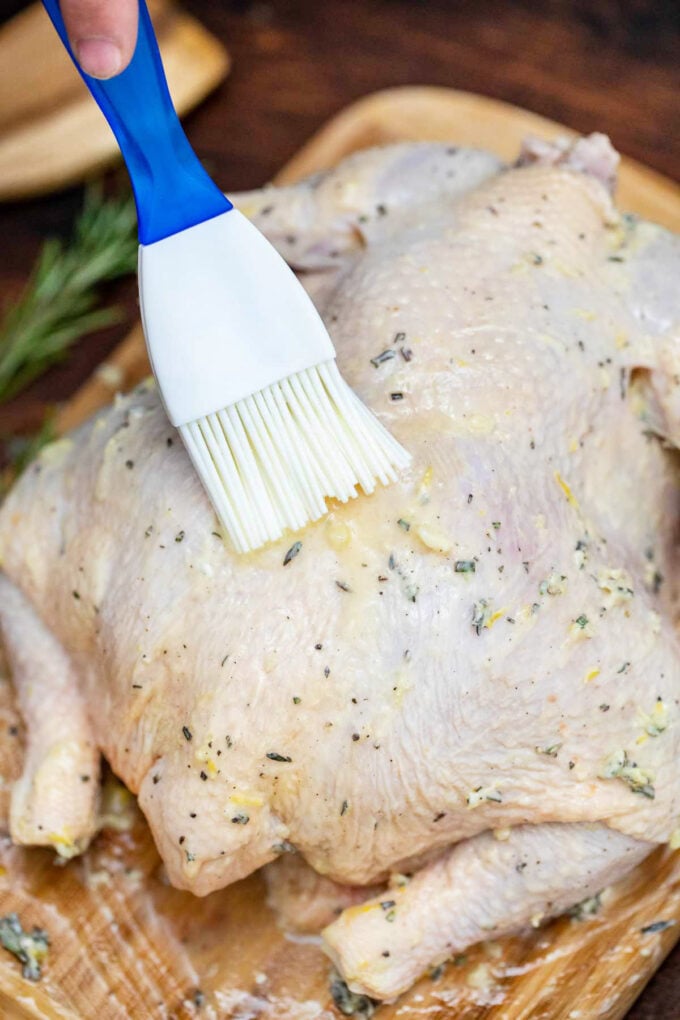 Brushing the chicken with lemon, butter, and oil mixture for chicken.