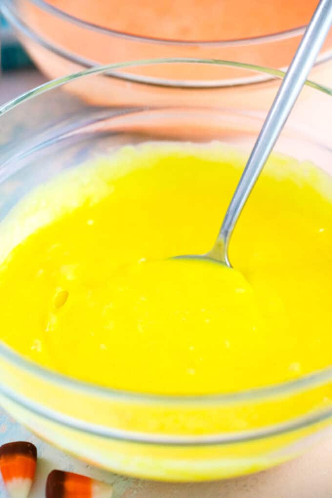 yellow and orange cake batter in bowls