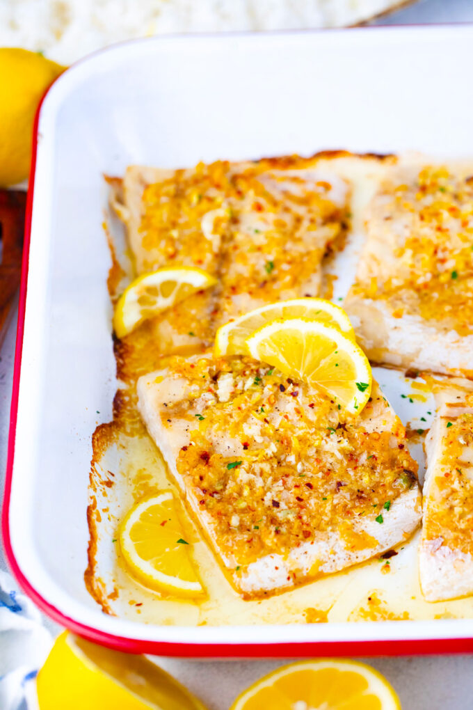 Golden-brown baked lemon garlic tilapia in a baking dish.