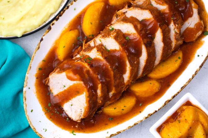 Sweet and savory slow cooker peach pork over mashed potatoes.