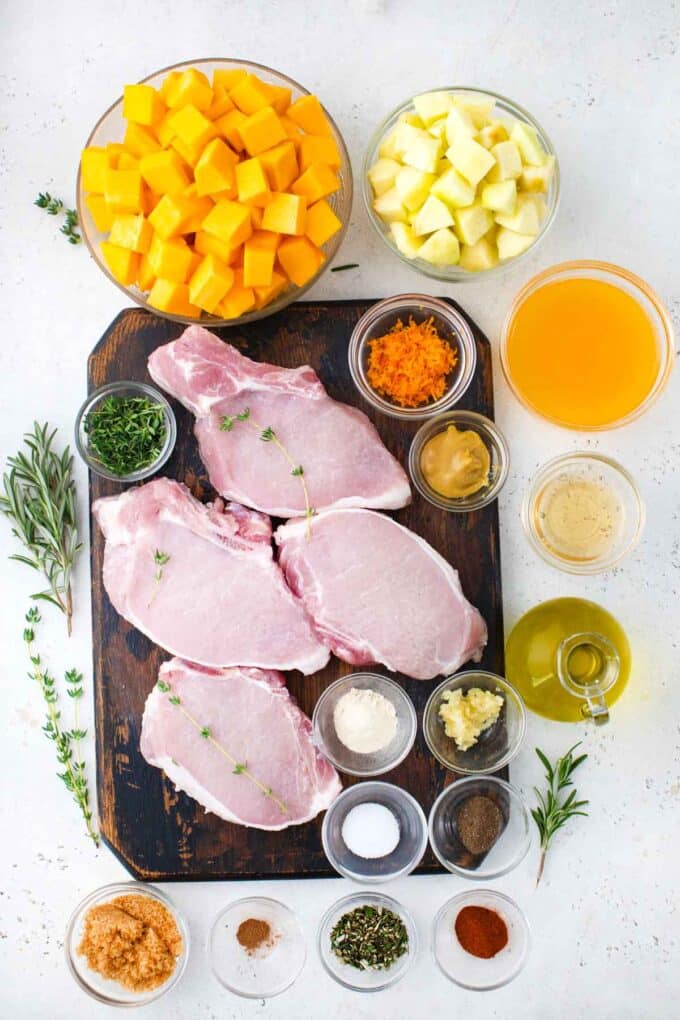 pumpkin pork chops ingredients in bowls on a table and pork chops on a cutting board