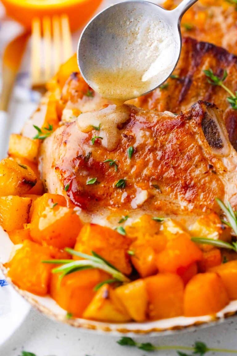 pouring maple mustard dressing over juicy apple pumpkin pork chops