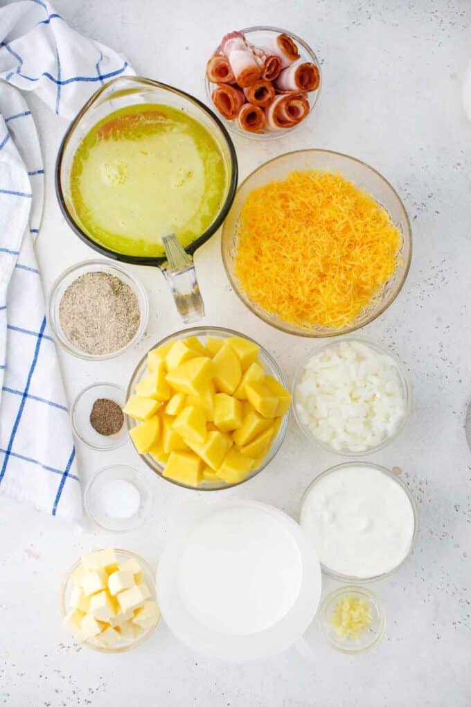 slow cooker bacon ranch potato soup ingredients in bowls on a table