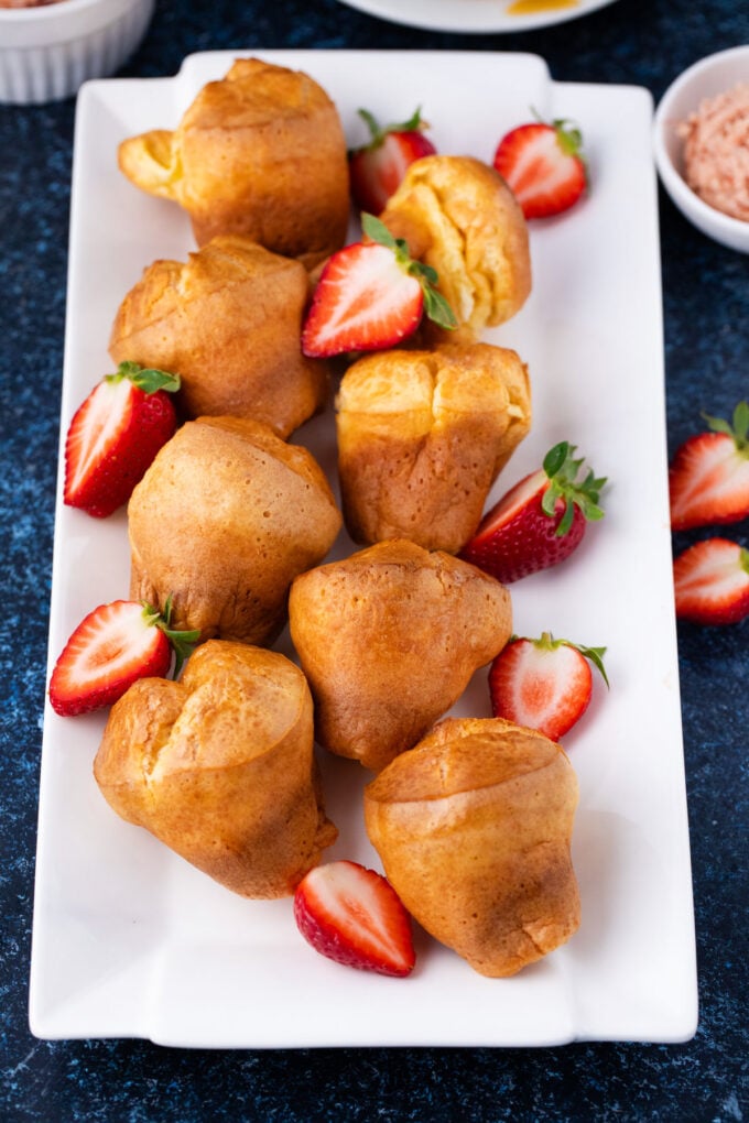 Homemade popovers on a plate with strawberries.