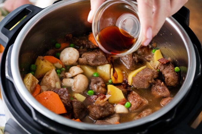 Adding the lamb stew ingredients to the Instant Pot.