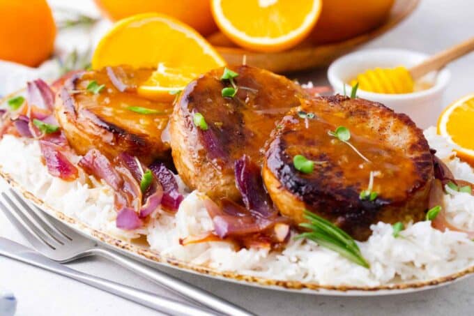 orange glazed pork chops on a pile of served