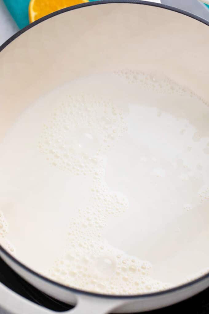 simmering milk in a white saucepan