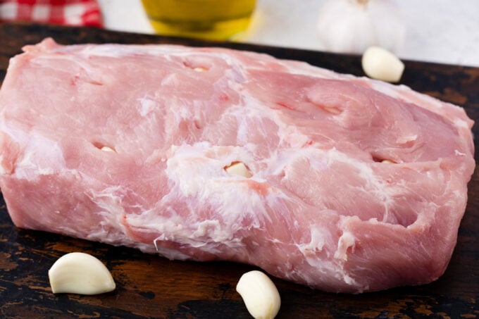 Stuffing pork loin with garlic cloves.