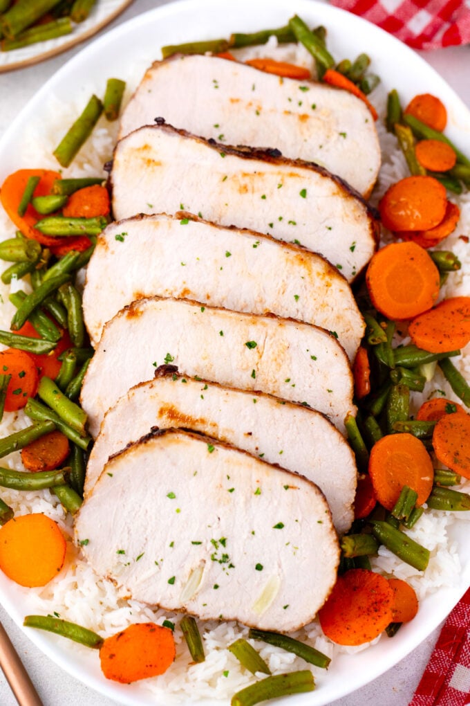 Sliced brown sugar roasted pork loin with green beans and carrots.