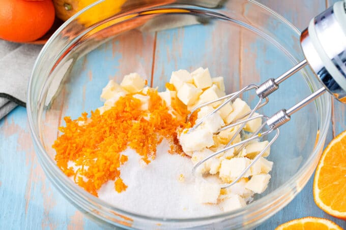 Beating butter with sugar, orange zest, and lemon zest.