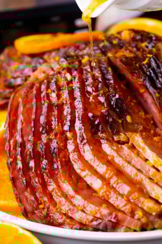 Drizzling glaze over slow cooker brown sugar ham.