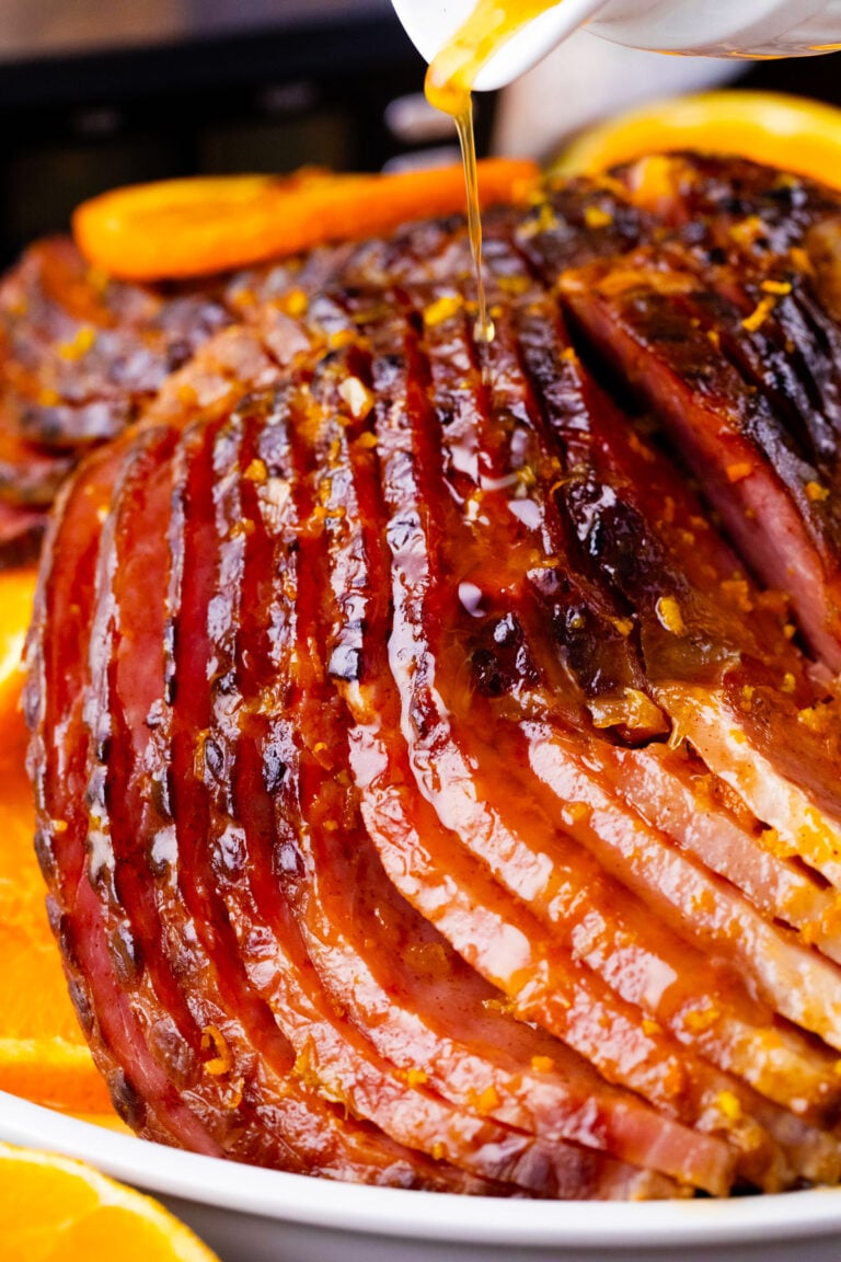Drizzling glaze over slow cooker brown sugar ham.