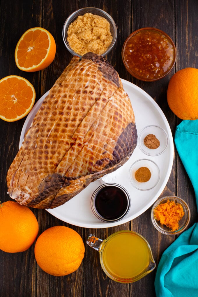 Overhead shot of slow cooker brown sugar ham ingredients arranged on a wooden surface.