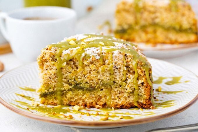Pistachio coffee cake slice with a pistachio spread layer in the middle.