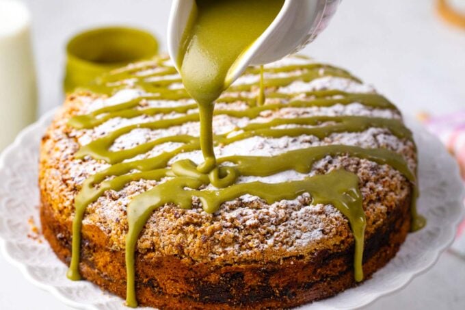 Drizzling pistachio sauce on top of pistachio coffee cake.