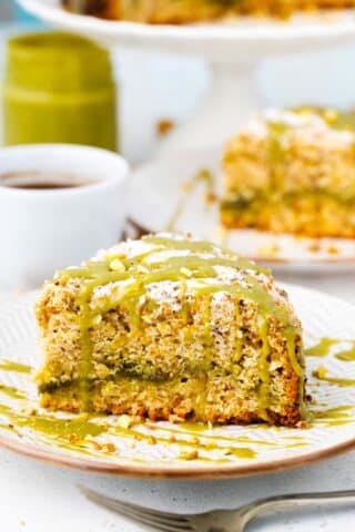 Sliced pistachio coffee cake with pistachio spread layer and topped with pistachio cream.