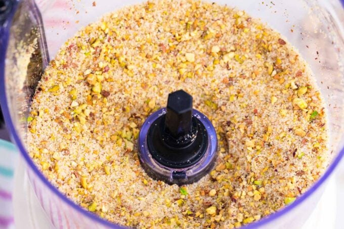 Mixing pistachios and sugar in a food processor.