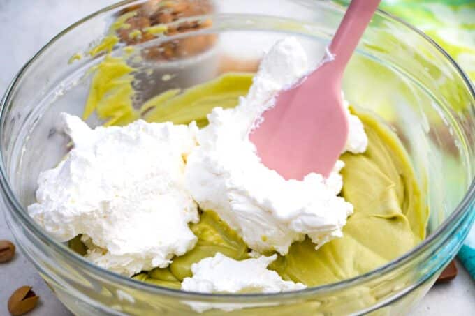 Folding whipped cream into pistachio mascarpone.