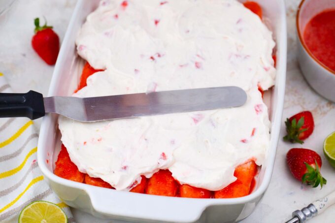Topping strawberry dipped Savoiardi cookies with strawberry cream.