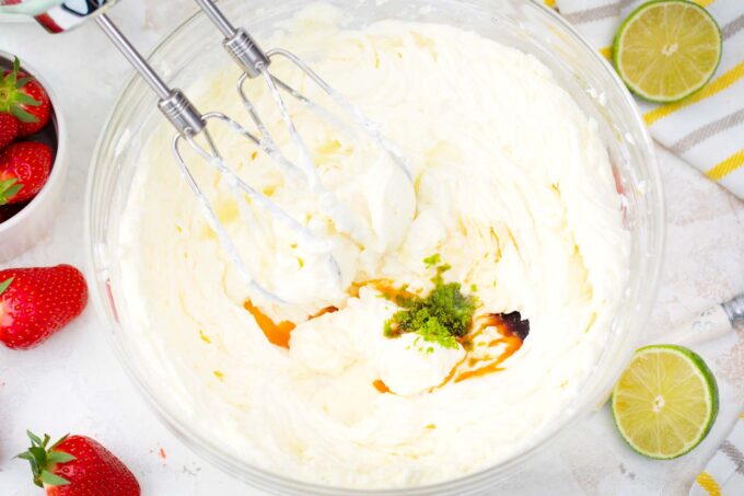 Whisking lime zest, lime juice, and vanilla extract into mascarpone cream.