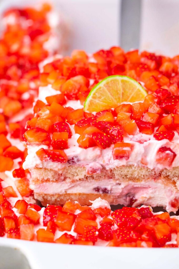 A slice of creamy strawberry margarita tiramisu on a serving spatula.