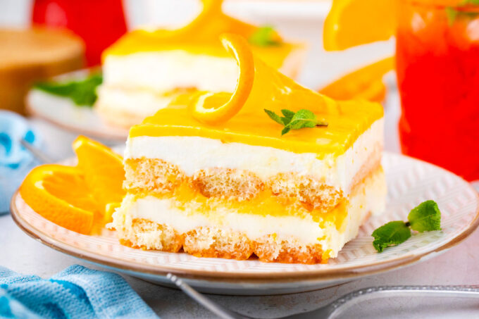 A slice of Aperol spritz tiramisu topped with orange curd.
