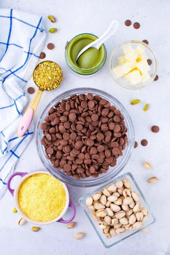 Overhead shot of Dubai chocolate pistachio cups ingredients in bowls on a table.