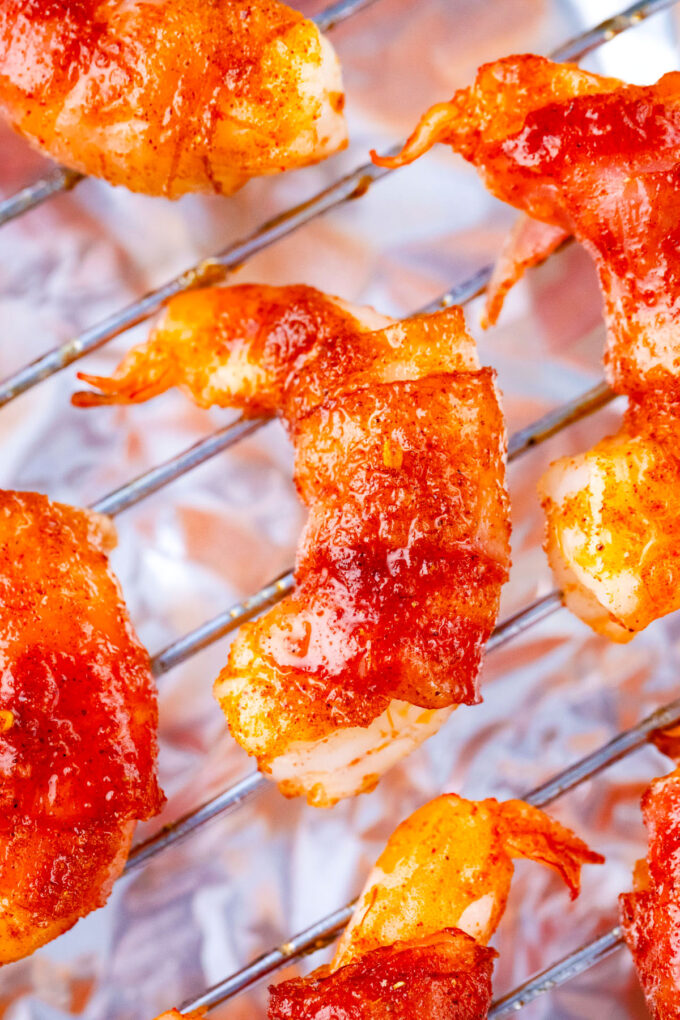 Sticky bacon wrapped shrimp with brown sugar on a wire rack.