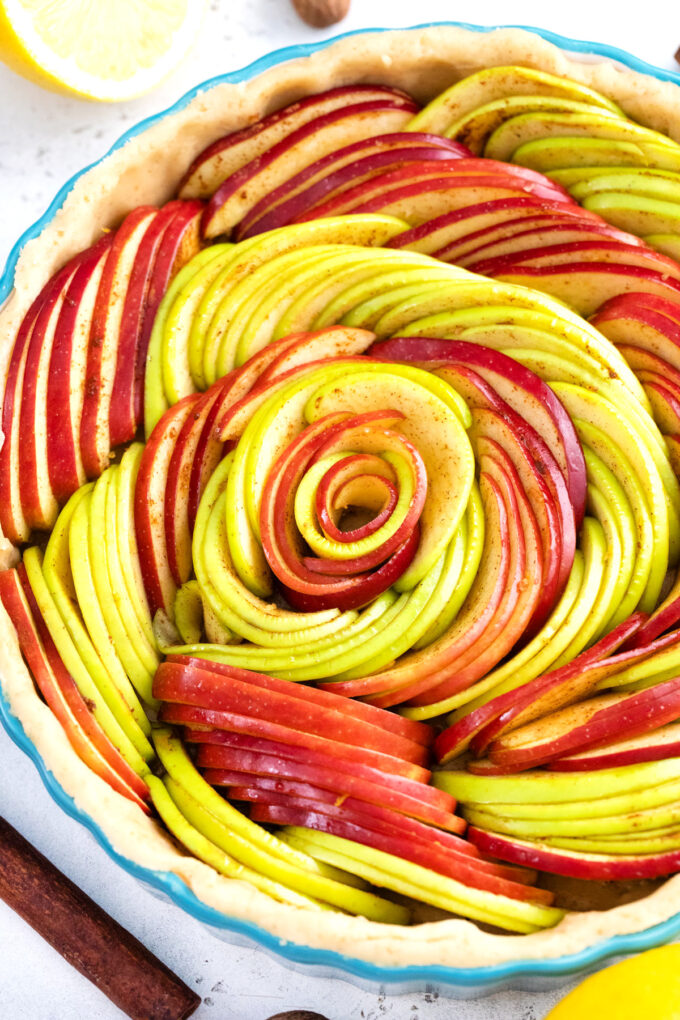 Overhead shot of apple tart in a rose pattern before baking it.