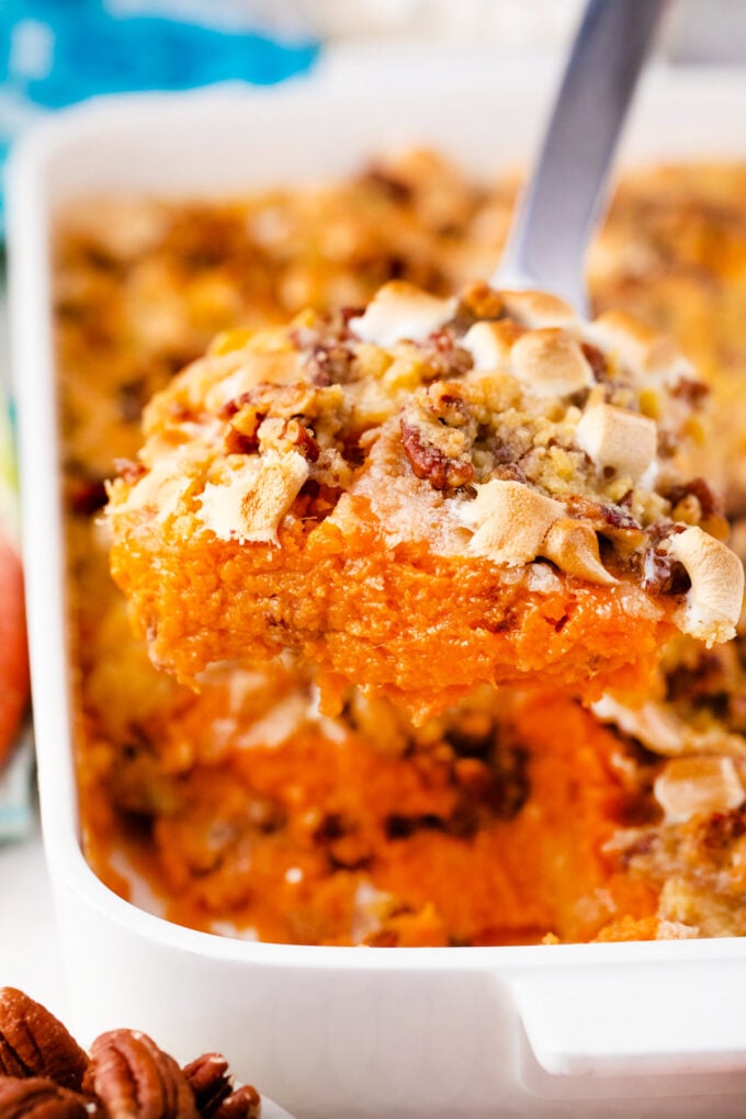 A serving of sweet potato casserole topped with marshmallows and pecans.